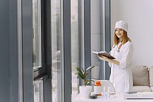 White nurse standing in a short term apartment